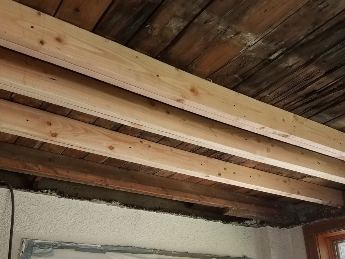 Wooden ceiling joists installed in a renovation project, showing structural support work.