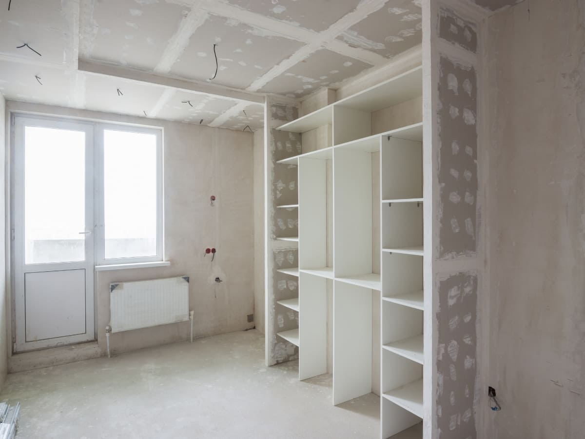 Unfinished room with new waterproofing and drywall installation in progress.