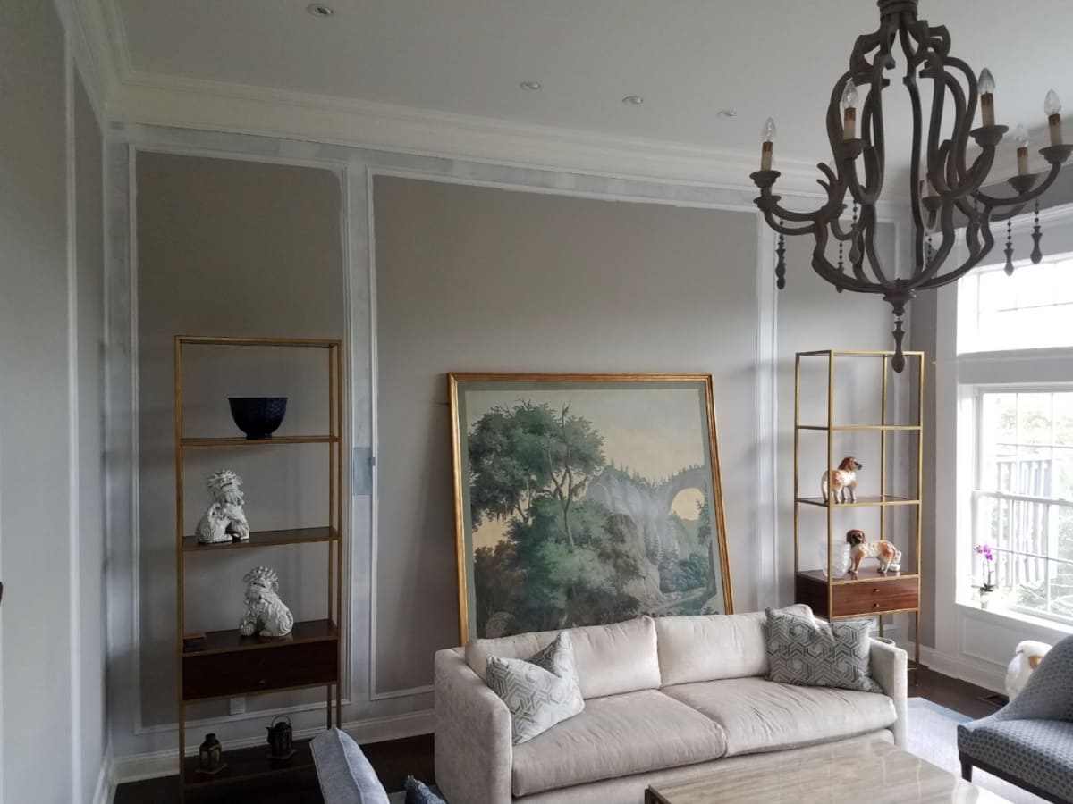 Living room with newly waterproofed walls, showcasing a chandelier and modern décor.