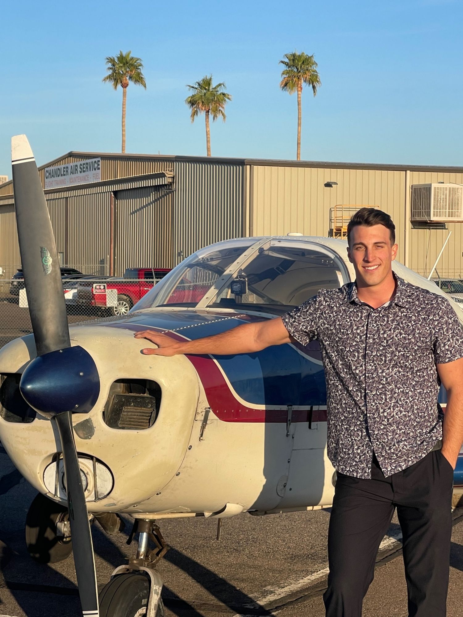 Braeden King, founder and flight instructor at Chi-Rho Aviation, standing beside a Piper at Chandler Municipal Airport
