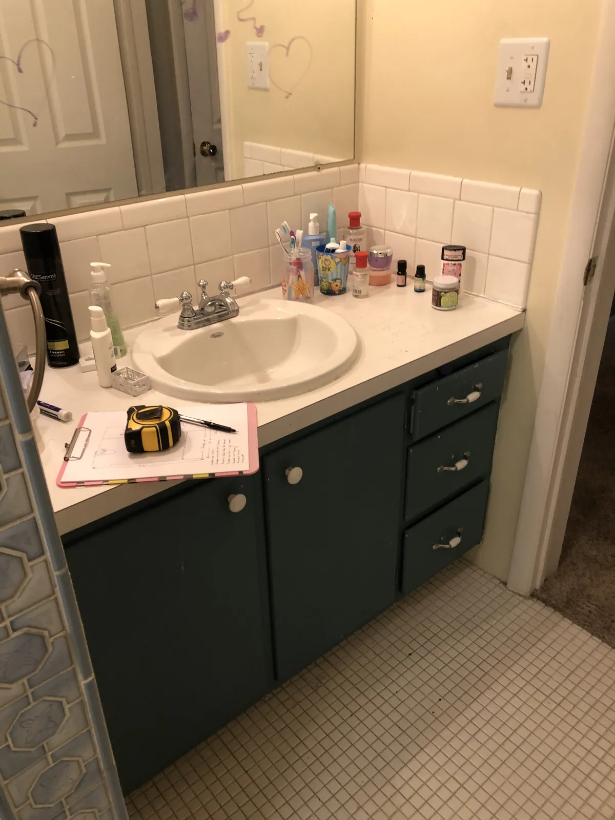 Bathroom vanity and sink area featuring a white tiled by...