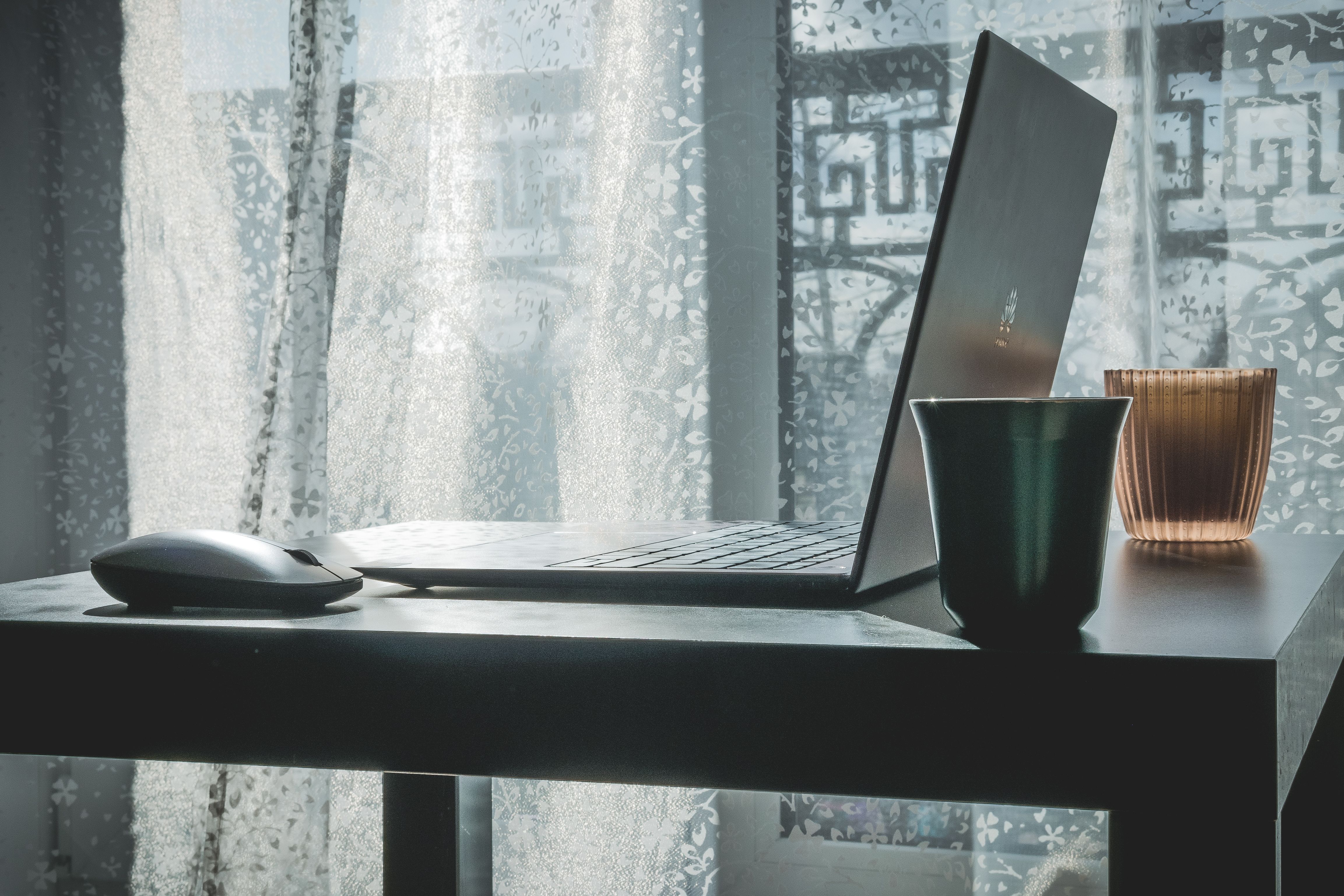 laptop and wireless mouse on desk