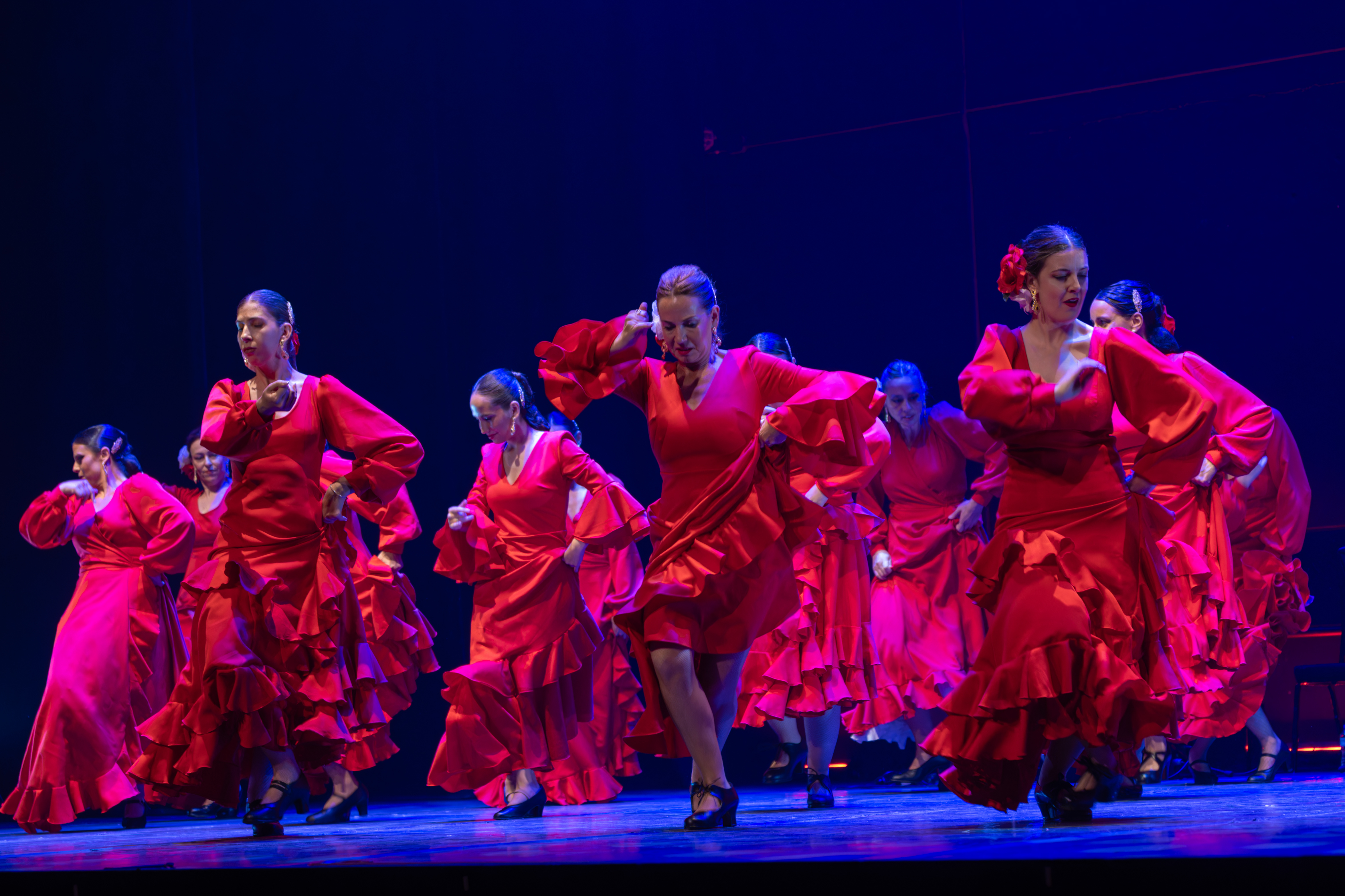 Grupo de alumnas de A RITMO bailando flamenco en el escenario
