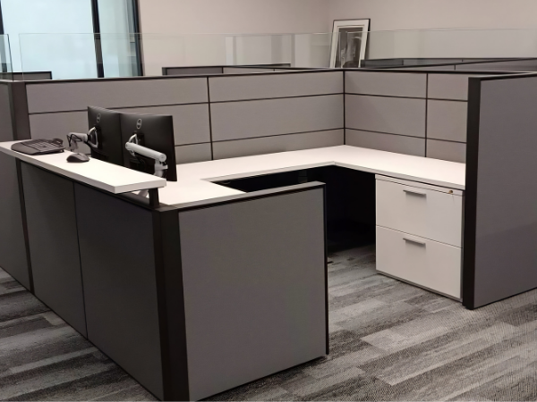 office cubicle workstation setup with desks partitions and computer monitors in commercial office space