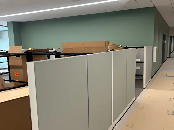 An office space with cubicle partitions and cardboard boxes, suggesting a recent setup or move.