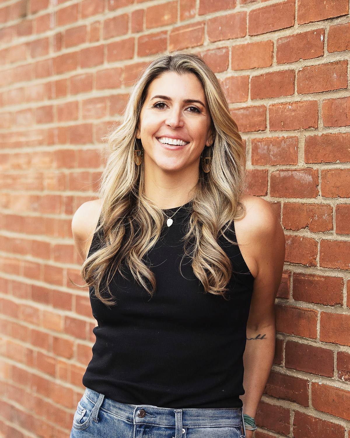 Carissa Hetrick smiling against a brick wall
