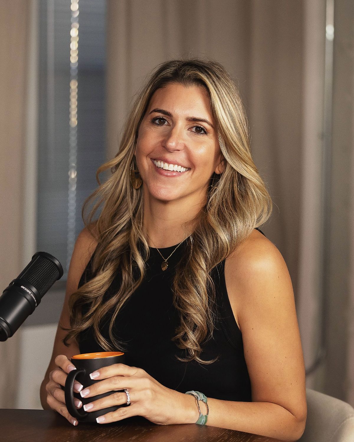 Carissa Hetrick at her podcast table with a coffee mug