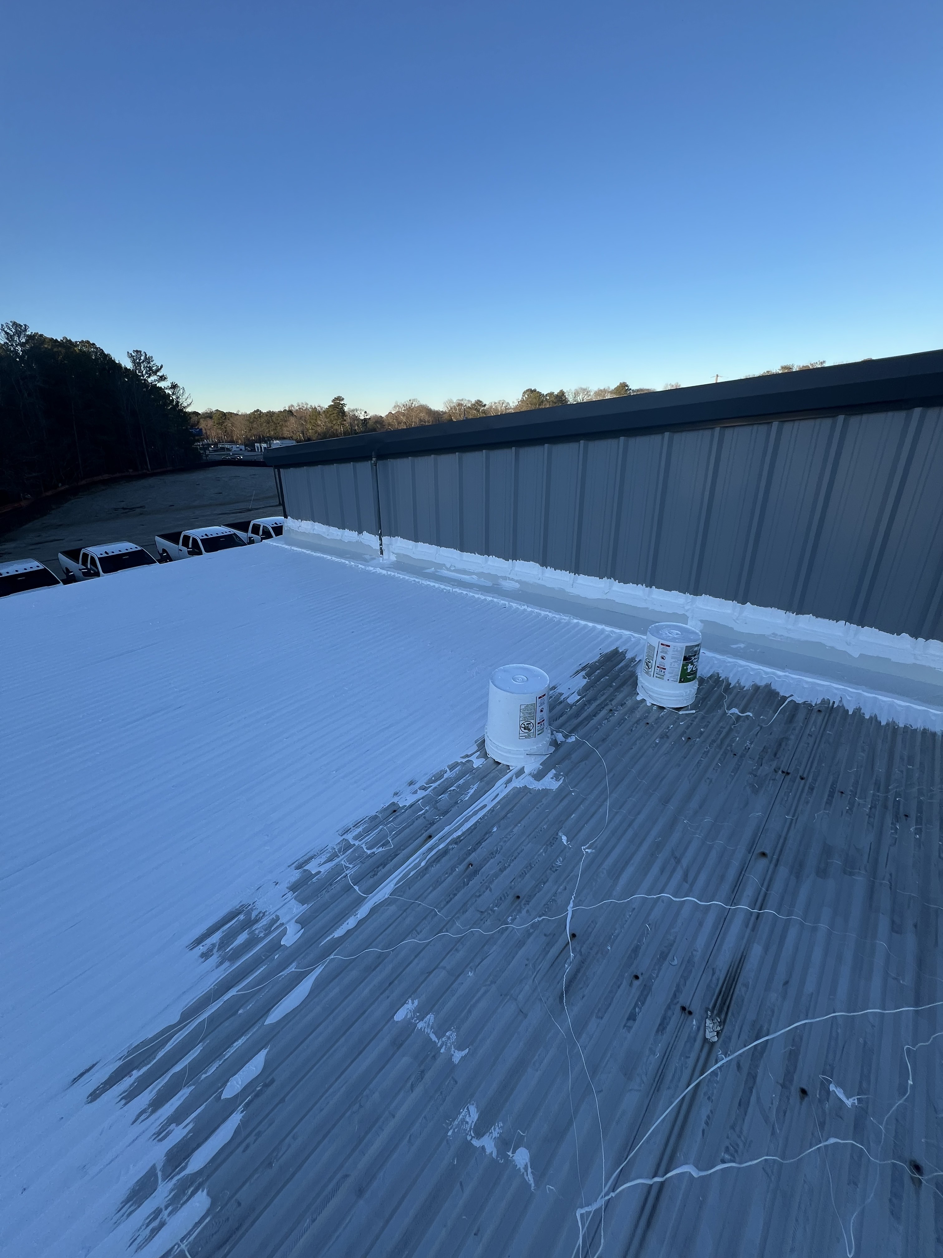 Storm damage repair in Jonesboro, GA Tropical metal roof coating application in progress Jonesboro GA - Rooftops Unlimited