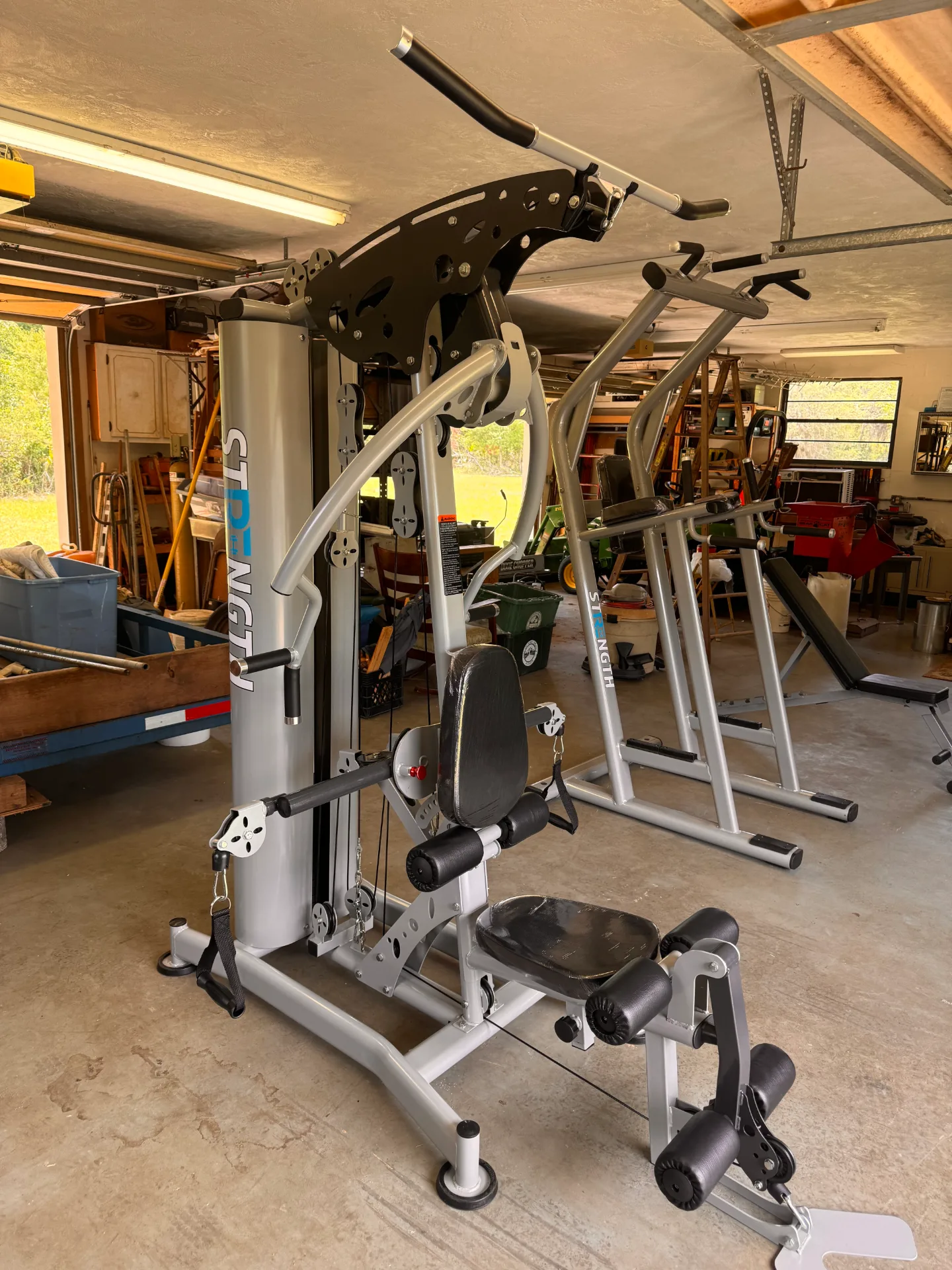 Multi-station strength machine in garage gym