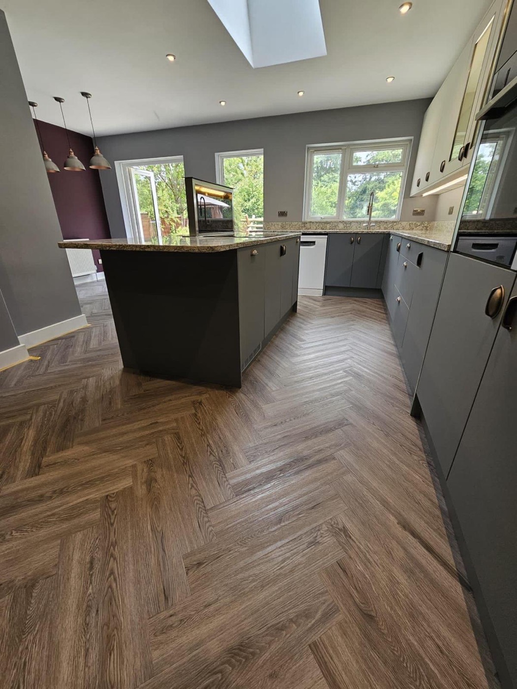 Open-plan living space with herringbone wood flooring
