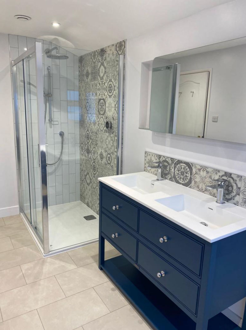 Bathroom with patterned grey wall tiles and blue vanity
