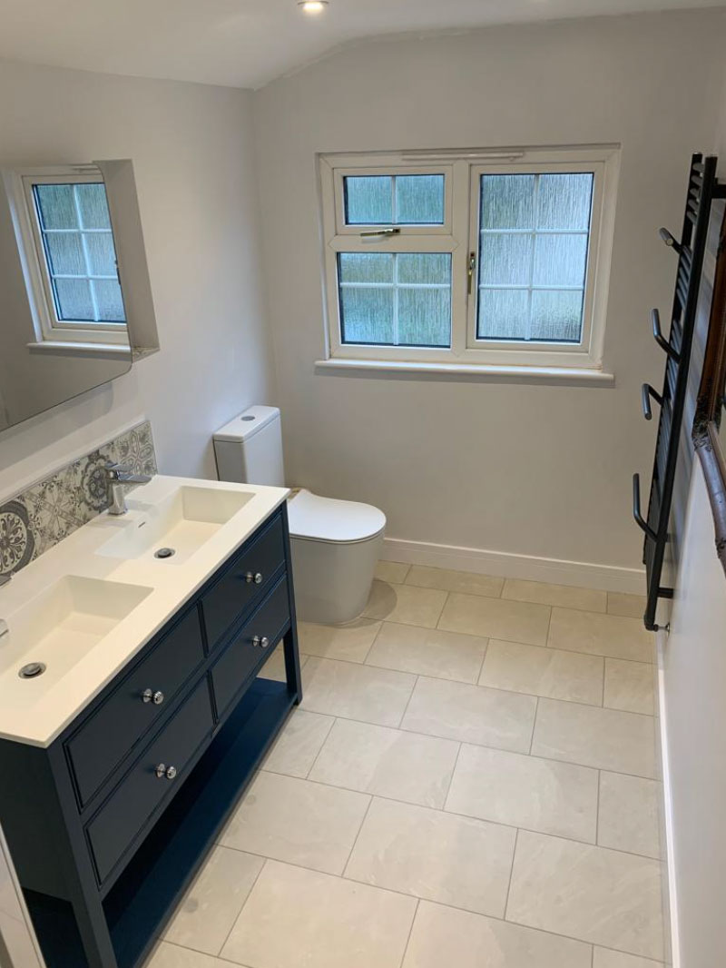 Renovated bathroom with a blue vanity unit and brass fittings