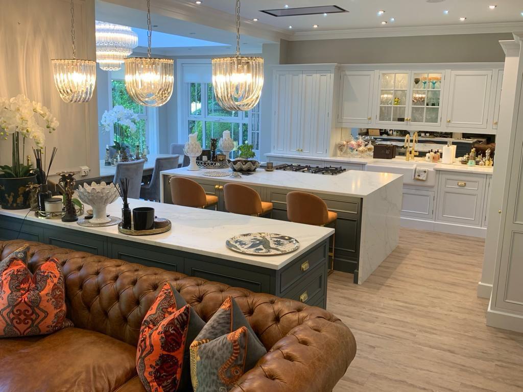 Open-plan kitchen with a marble island and glass pendants, fitted by our team