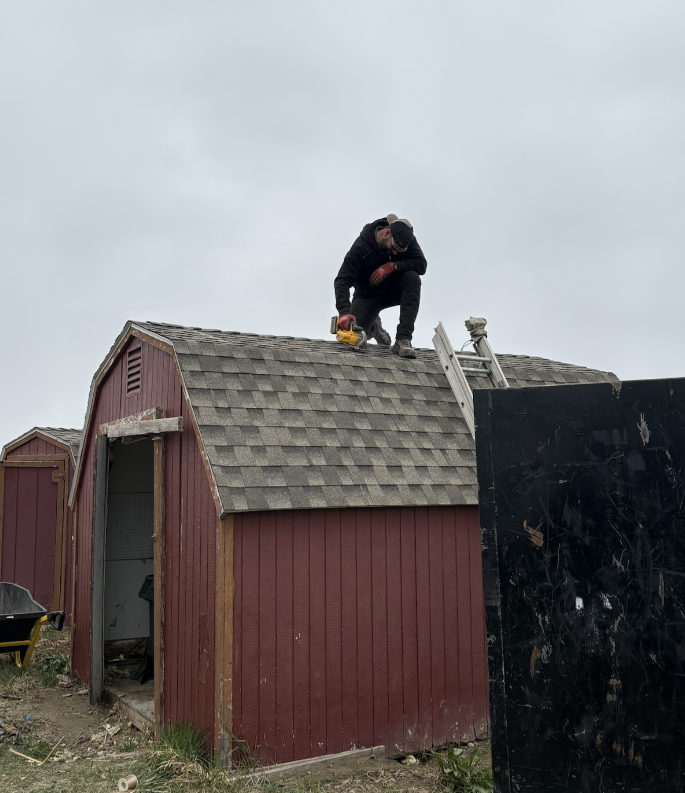 Ryan on top of shed with chainsaw during demolition Billings MT