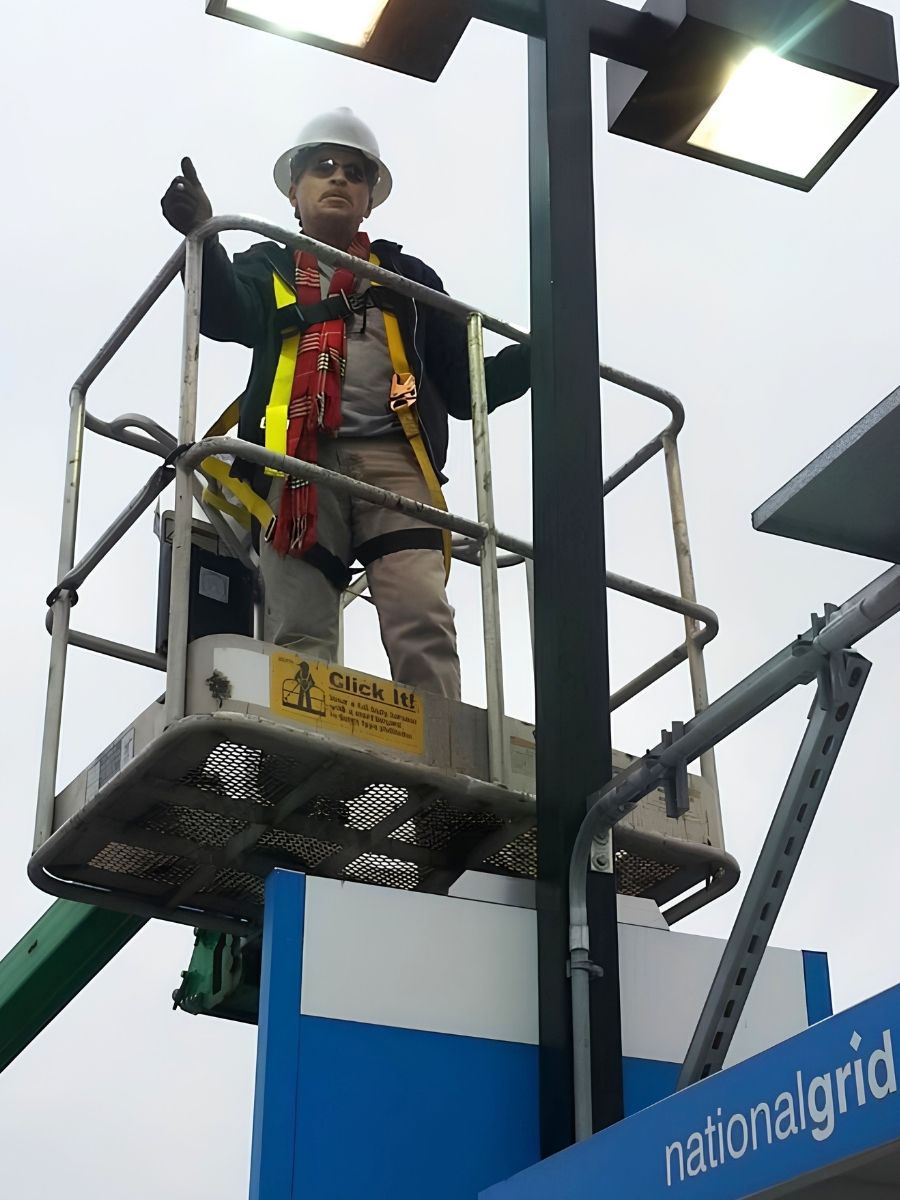 Robert Ladd, owner of Lighthouse Electric, working from a lift beside exterior lighting