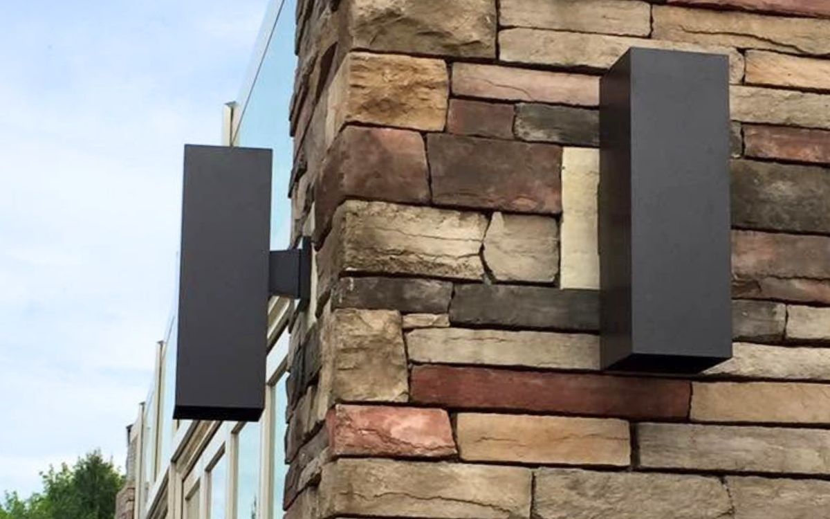 Modern exterior wall sconces mounted on a stone facade