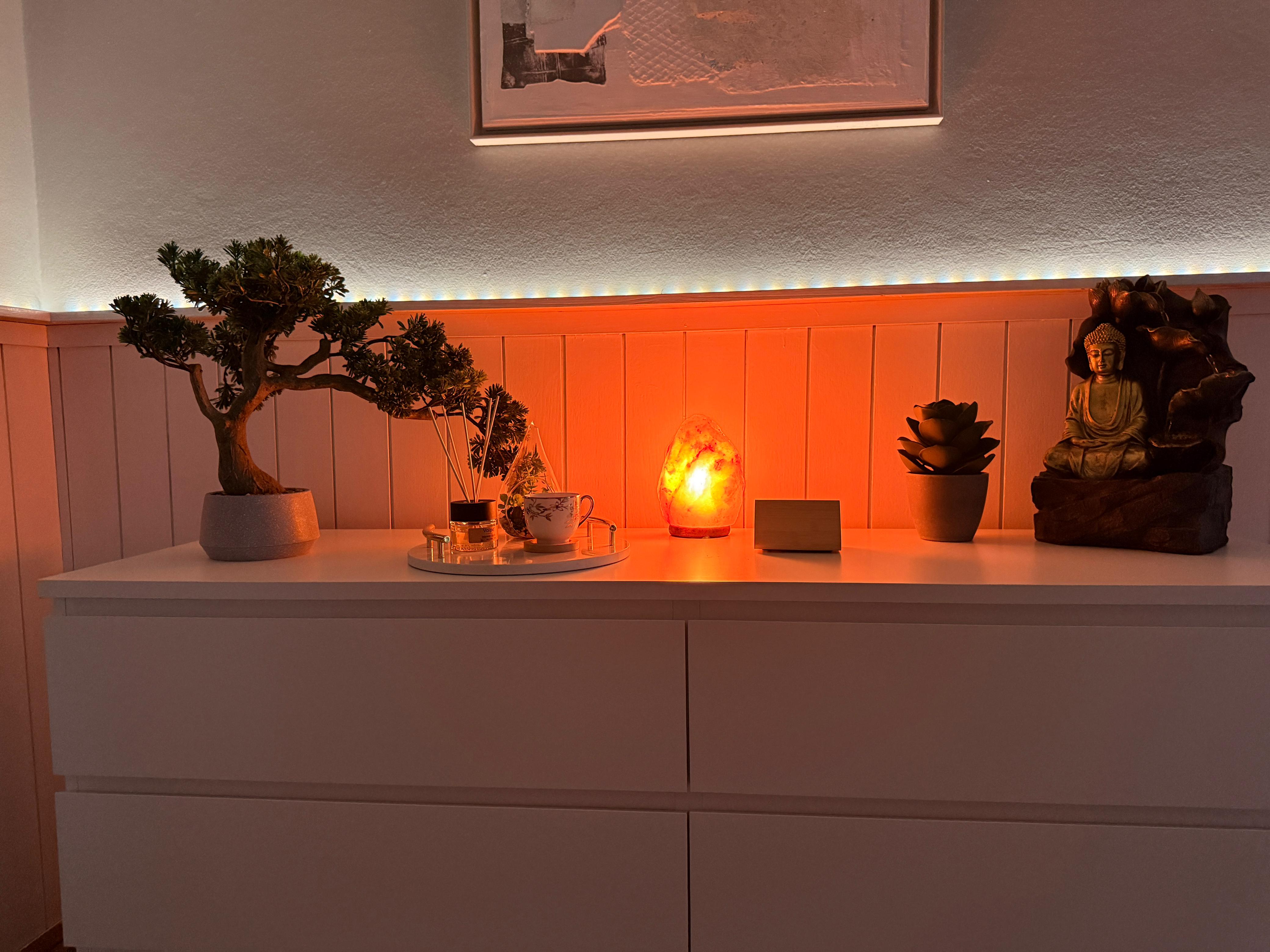 Gilded Buddha and aromatherapy oils on a shelf at Avora