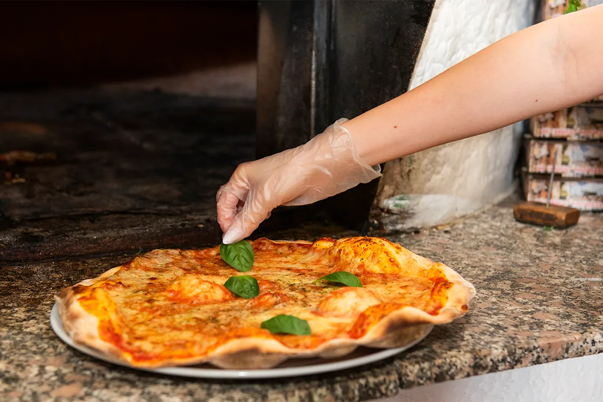 Frisch gebackene Holzofenpizza direkt aus dem Ofen