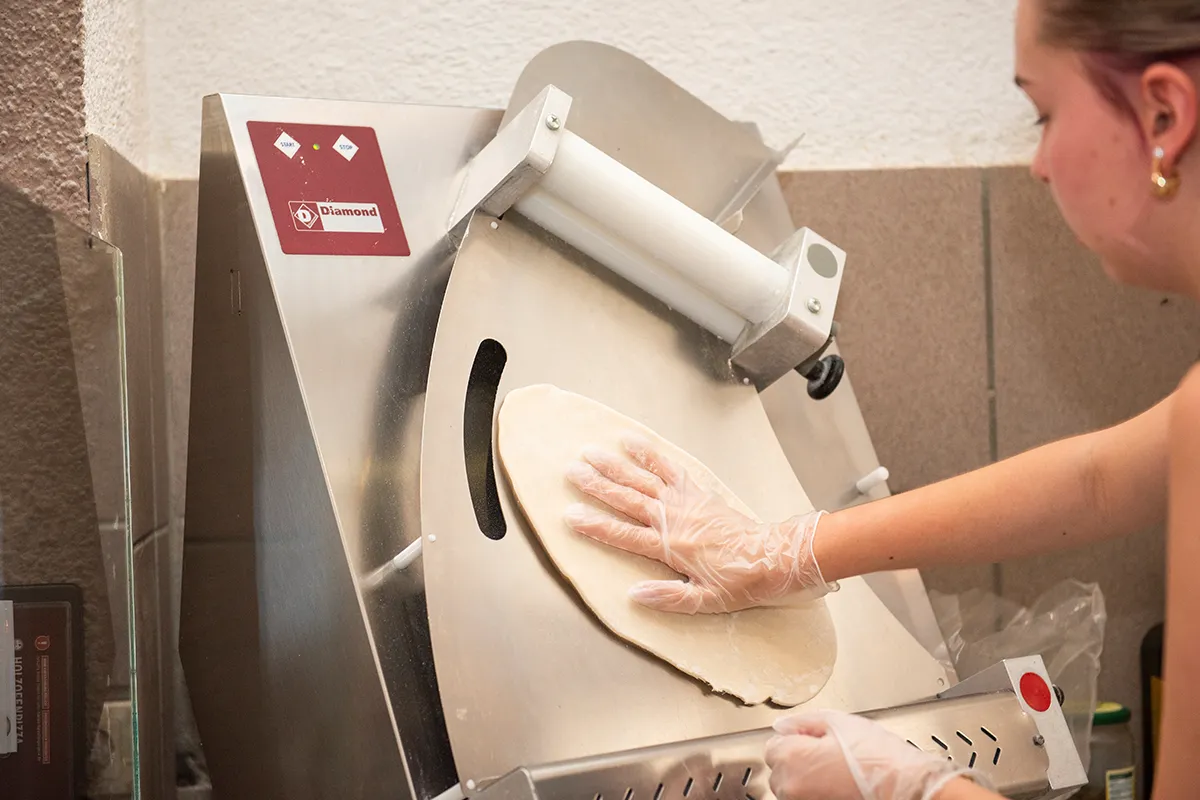 Frischer Pizzateig wird in der Küche von Hansl's Holzofenpizzeria geknetet