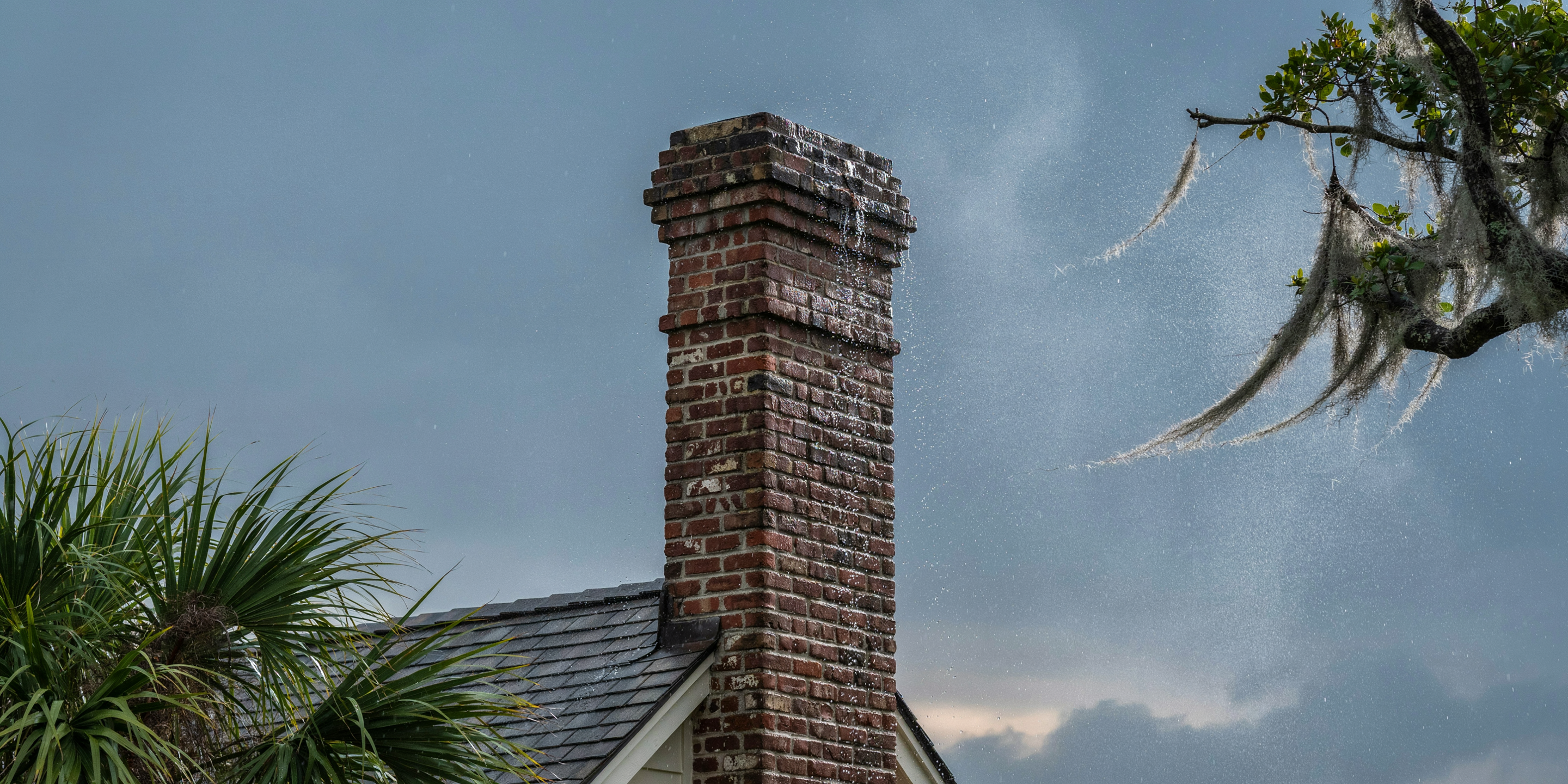 Wind-driven rain against a brick chimney