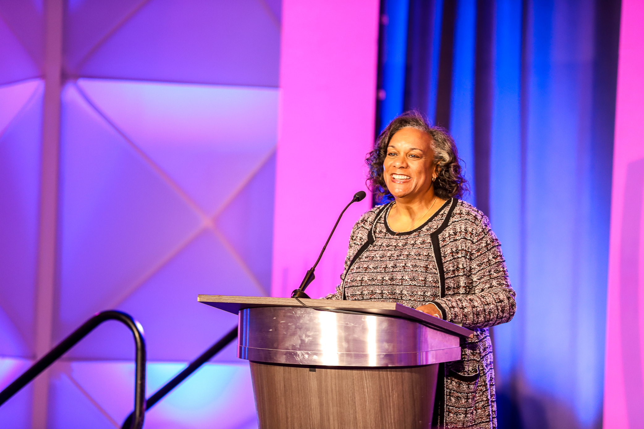 Dawn speaking at a podium, smiling