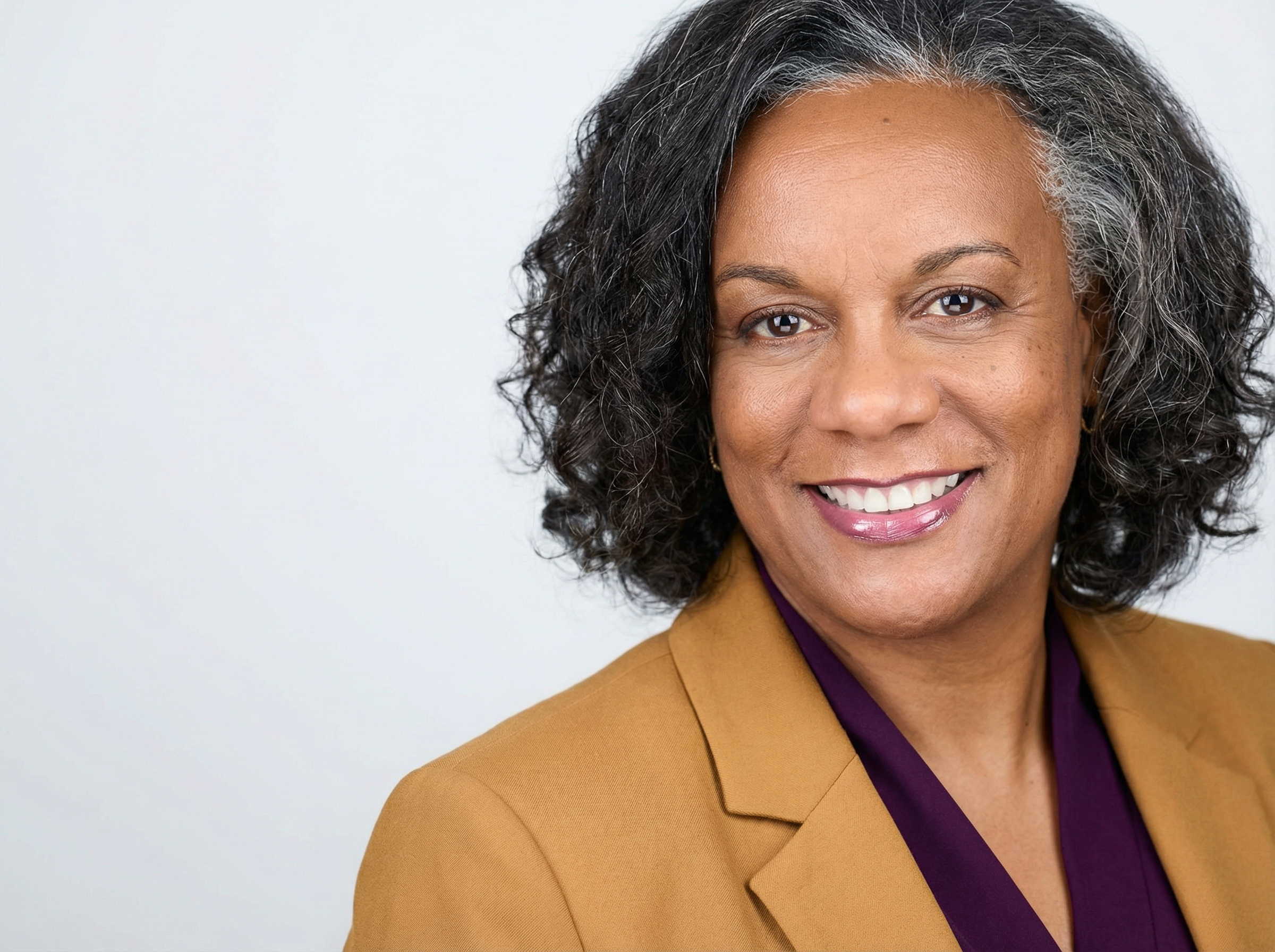 Dawn Jordan Jones, smiling, in a gold blazer and plum blouse
