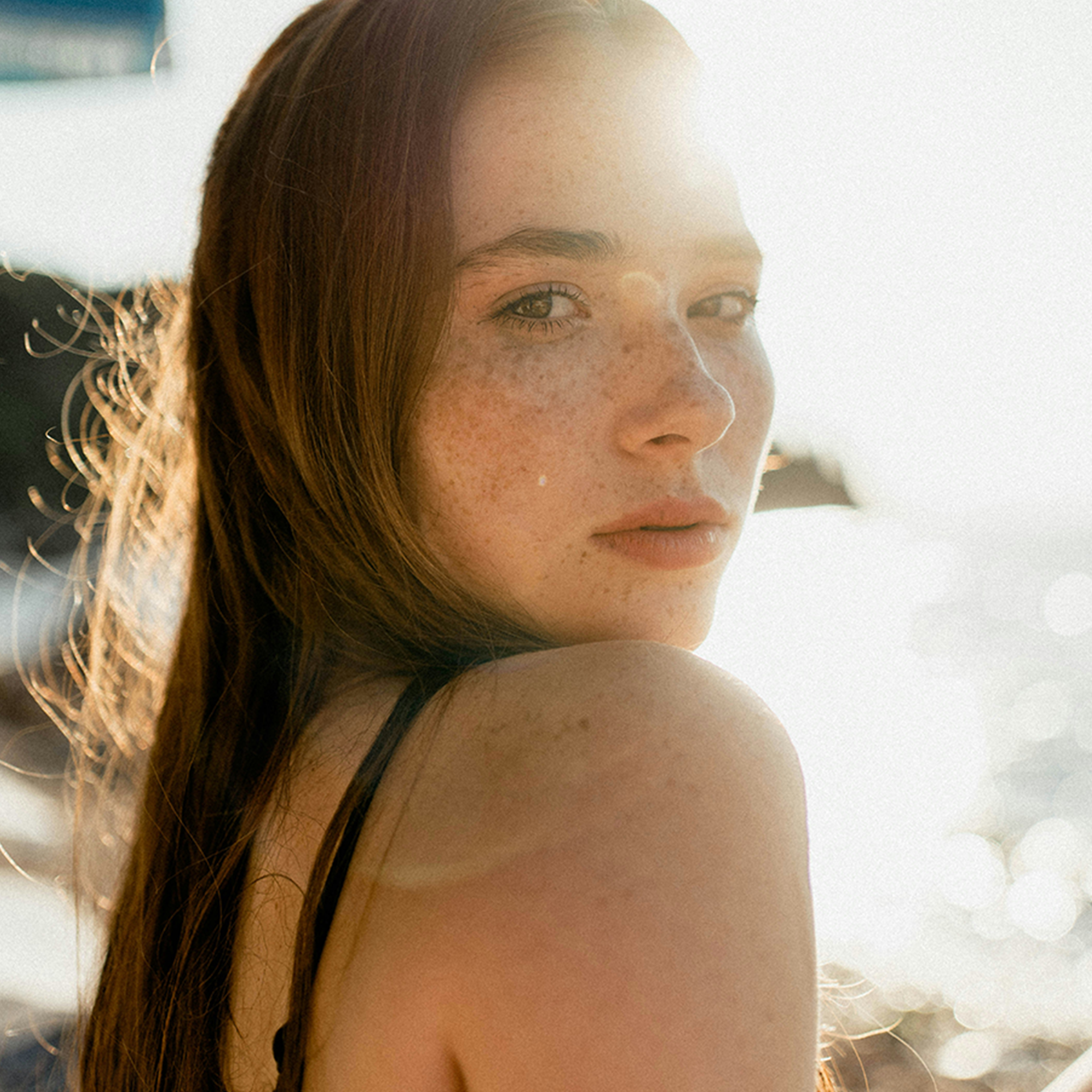 Woman with smooth, glowing skin in bright beach light