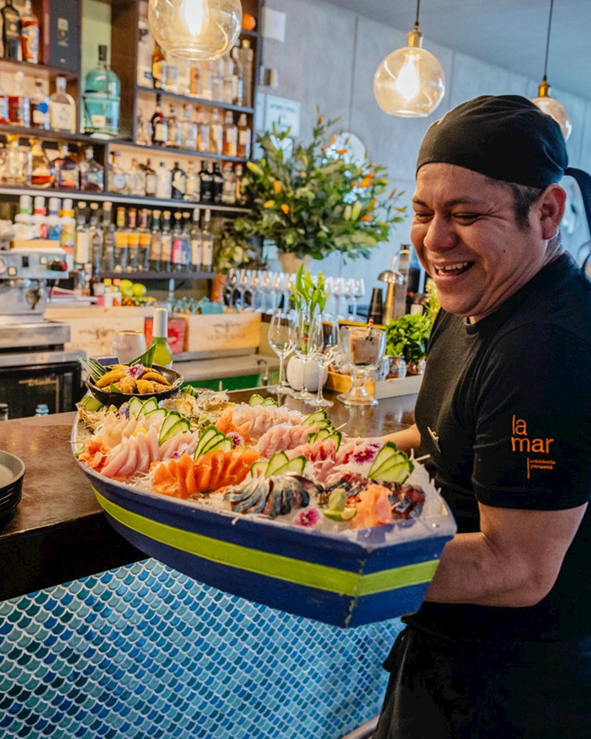 Chef presenting a refined seafood selection in a contemporary Lima restaurant