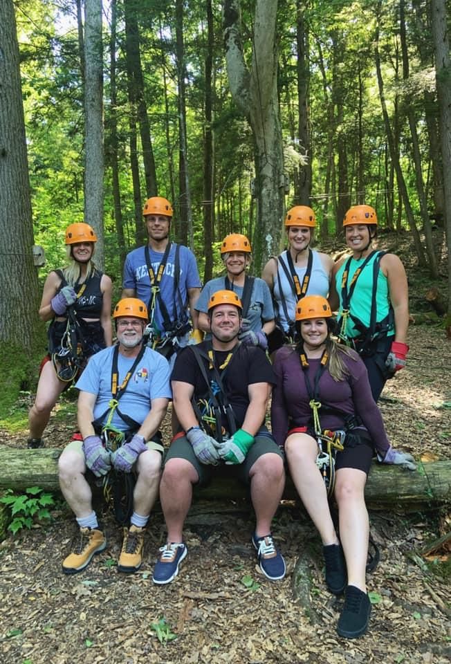 Sean Hyde with a group in zipline gear in a forest
