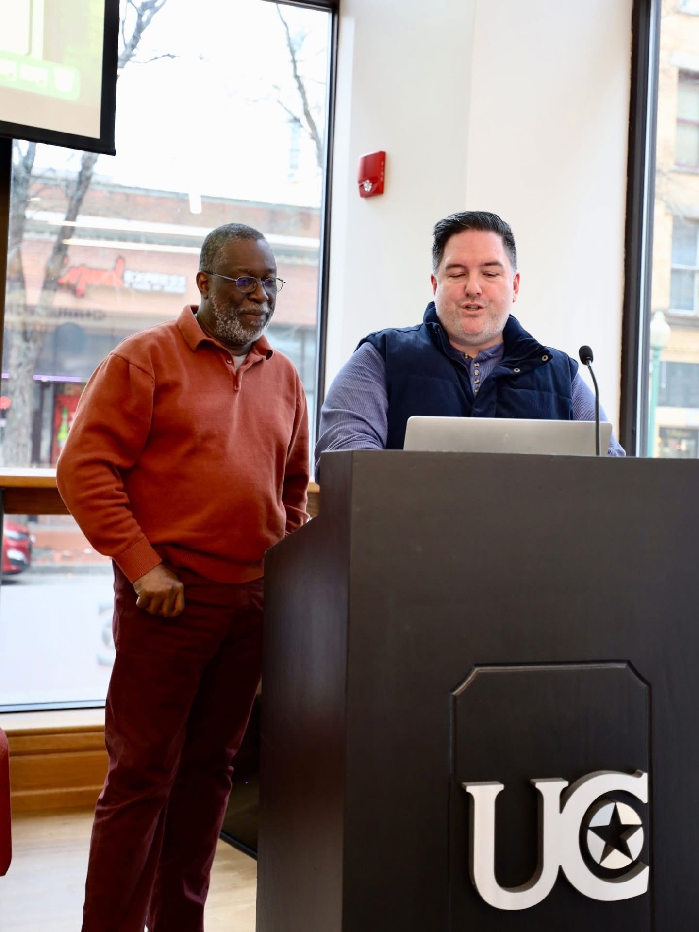 Sean Hyde and a co-host at the University of Charleston podium during a winter session