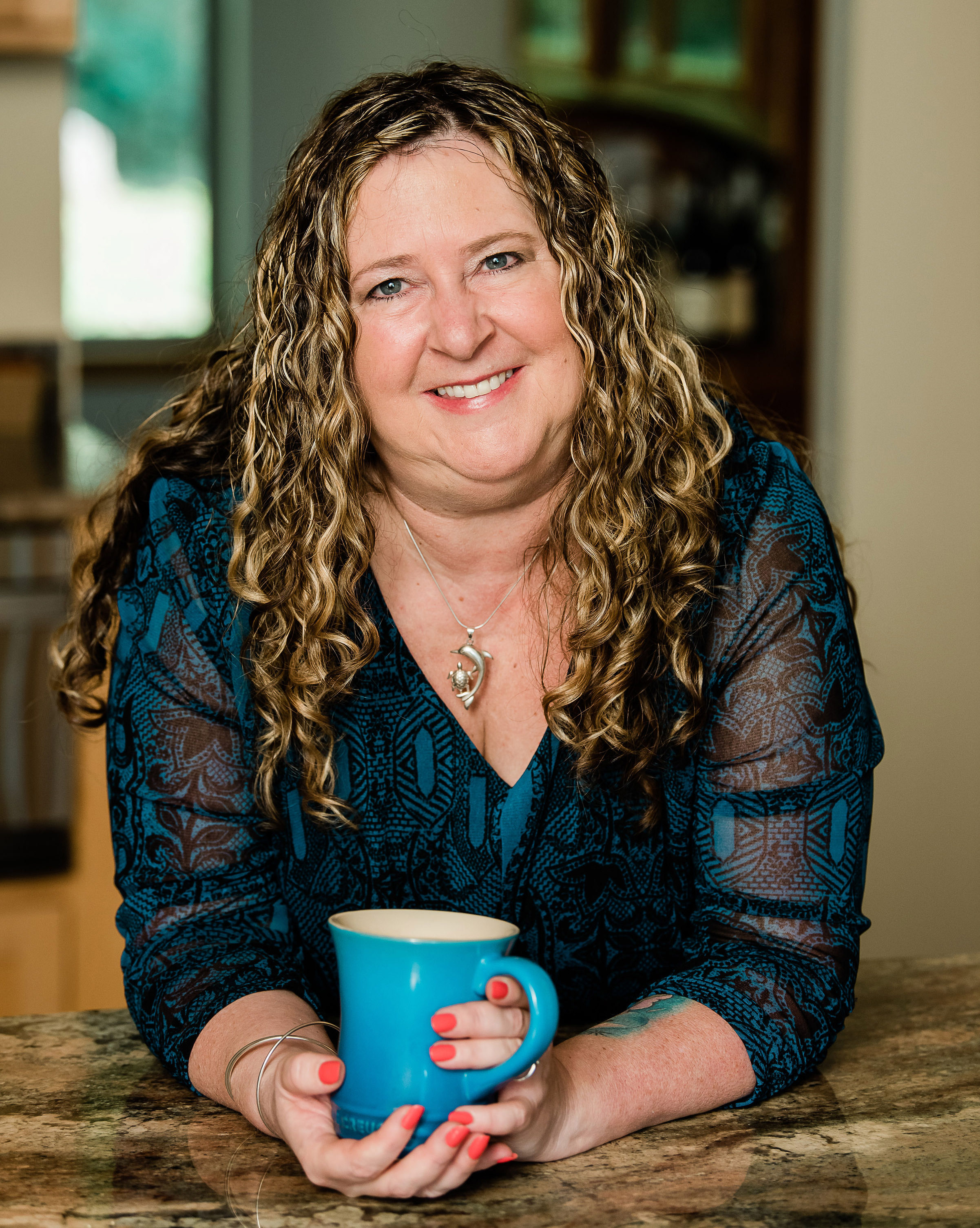 Pam Langord at her kitchen counter with a blue coffee mug