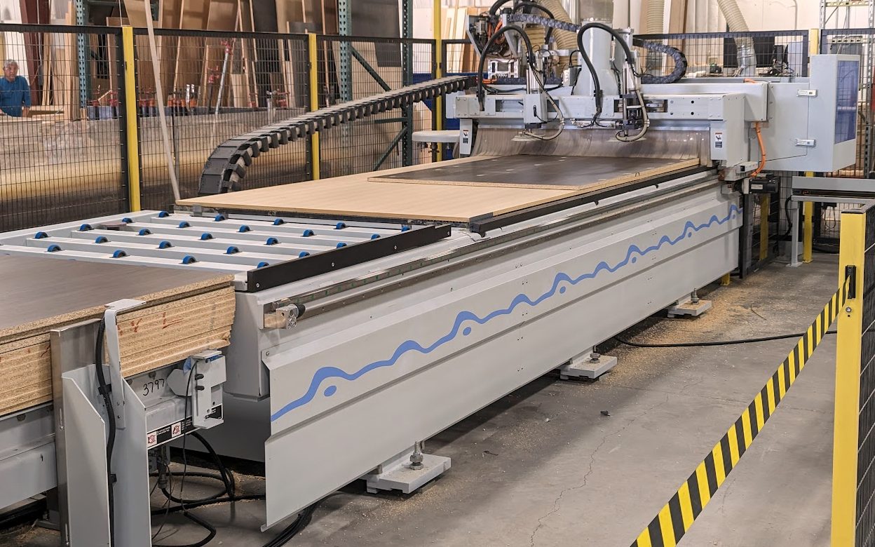 Industrial CNC router cutting 3/4 inch cabinet panels on the production floor