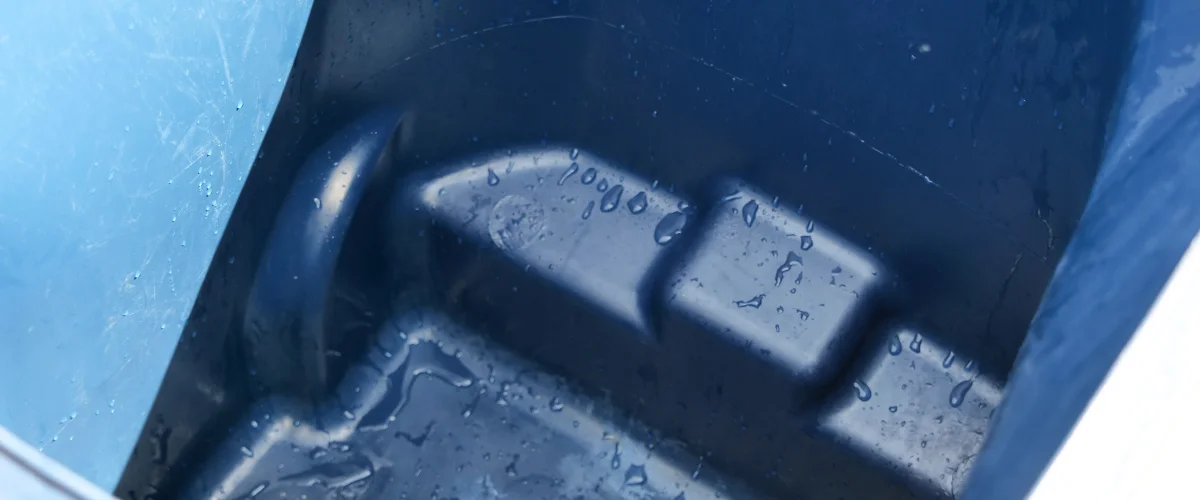 A close-up view inside a blue plastic container with water droplets clinging to its textured surface. A close-up view inside a blue plastic container with water droplets clinging to its textured surface.