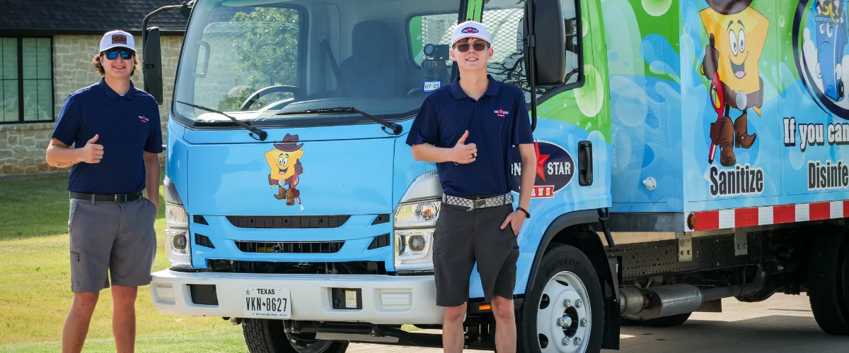 Two young men in blue polos, white caps, and sunglasses stand smiling with thumbs up next to a bright blue truck. Two young men in blue polos, white caps, and sunglasses stand smiling with thumbs up next to a bright blue truck.