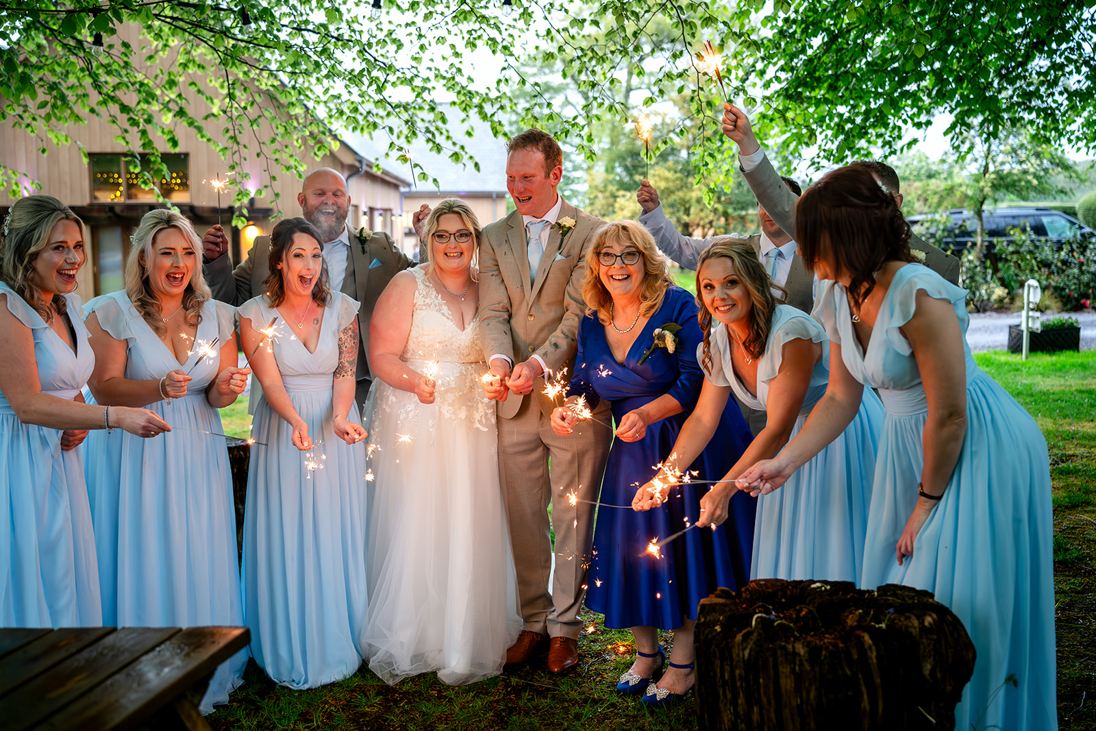 Wedding guests with sparklers by the firepit