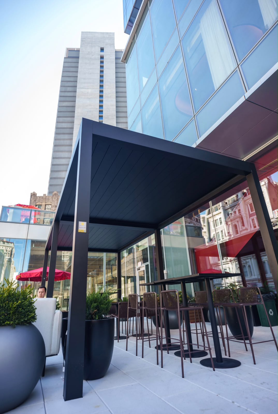 Commercial black louver pergola beside a modern building