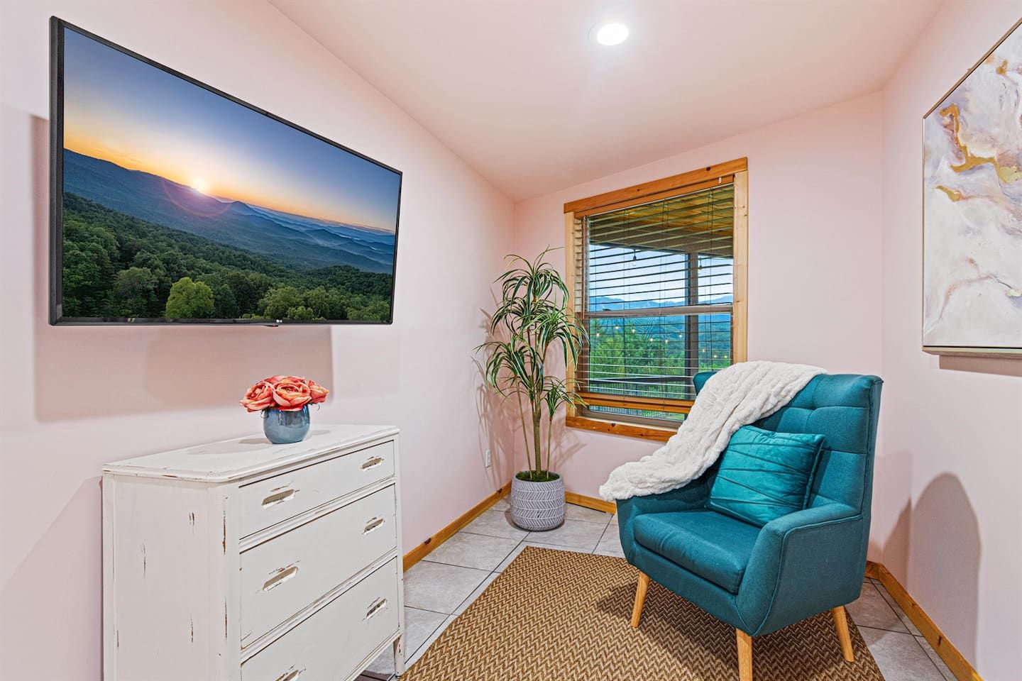 The queen bedroom radiates fresh ambiance, with a cozy sitting area by the window—perfect for morning reflections or evening relaxation—and a Smart TV for entertainment. This space blends comfort and charm, with views that elevate every moment.