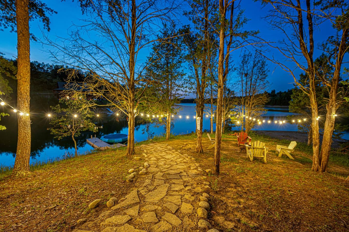 The lit stone path down to the waterfront is the walk everyone takes first, straight toward the lake until the day finally lets go of you.