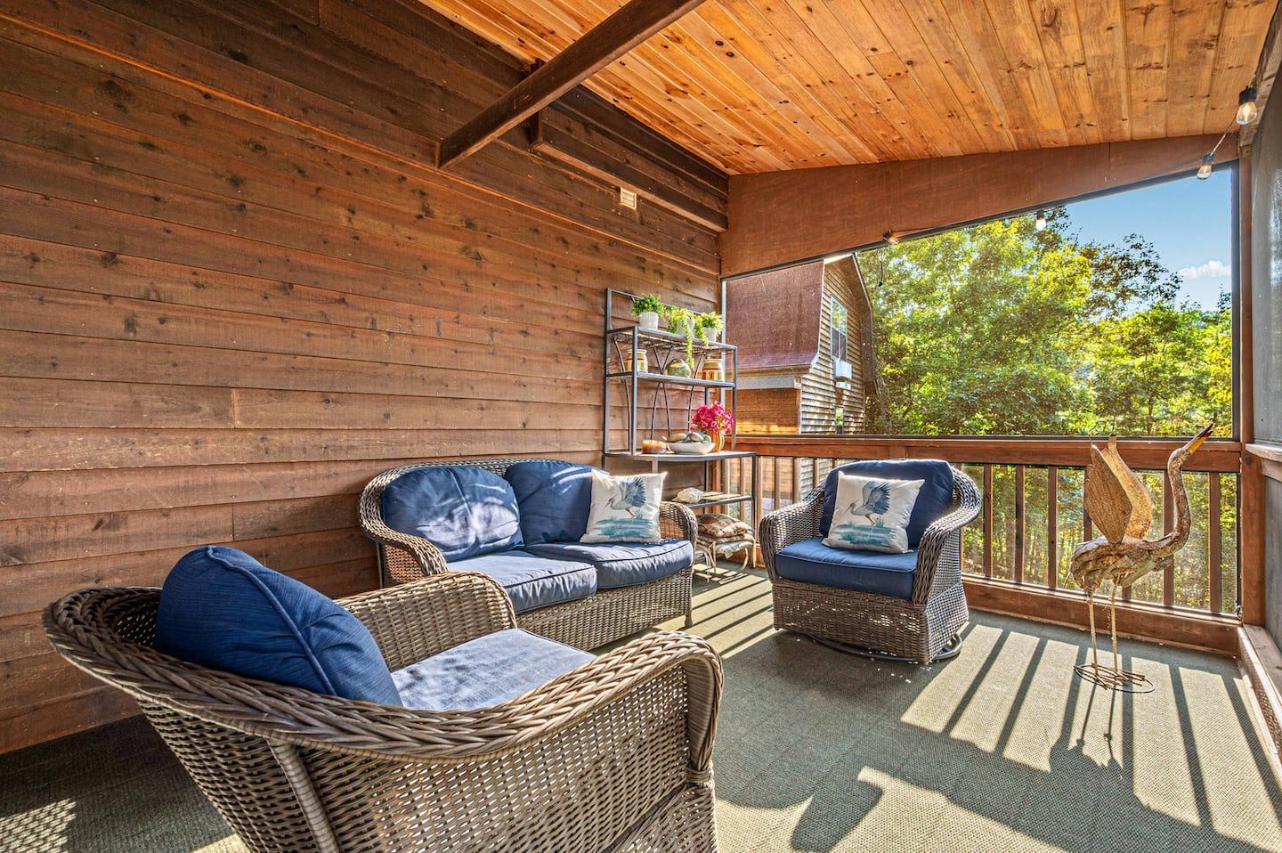 The covered lower porch off the hot tub, set up for slow lakeside mornings and long conversations.
