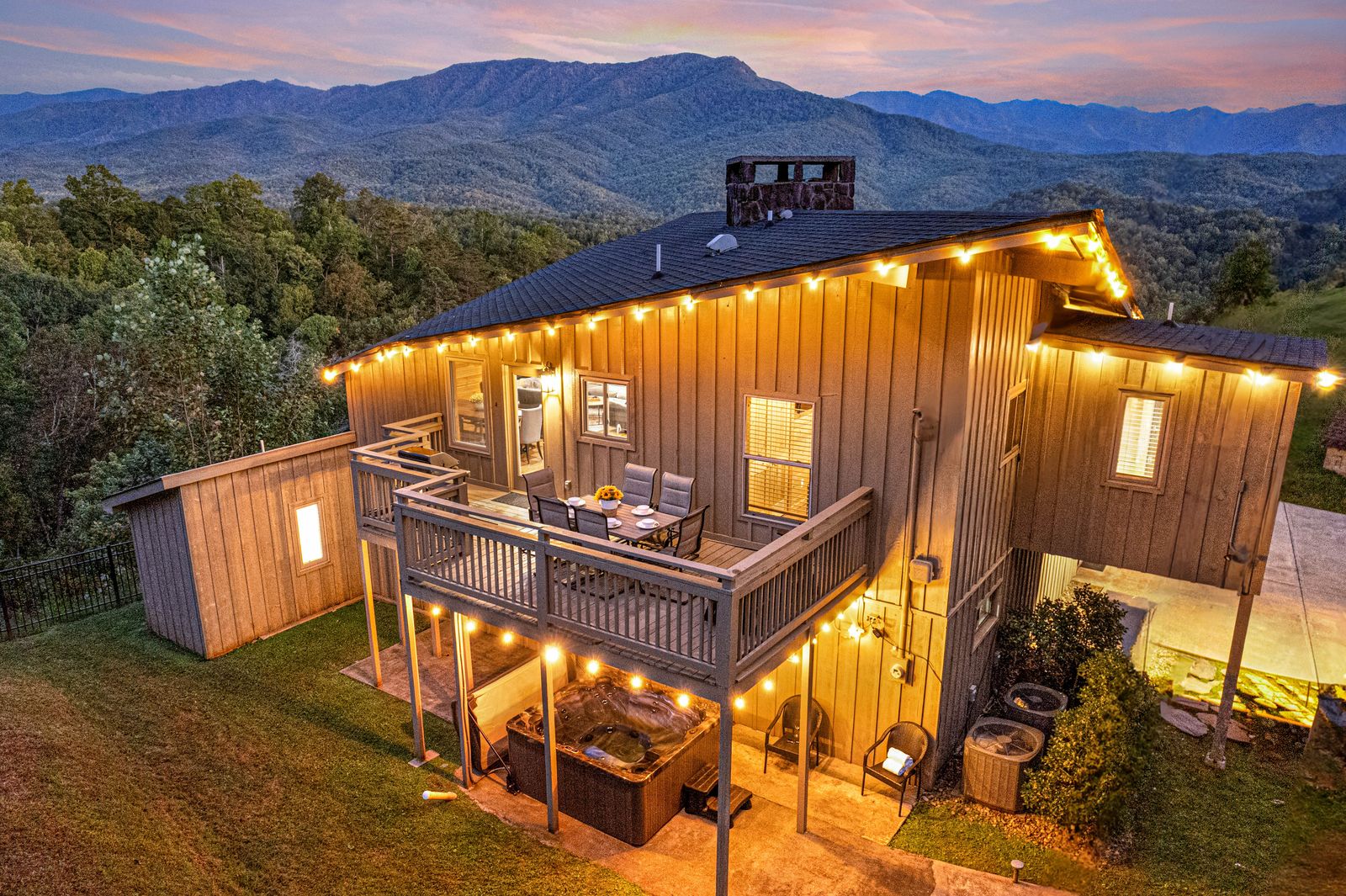 Birdsong Ridge at twilight, deck lights on, the mountains behind