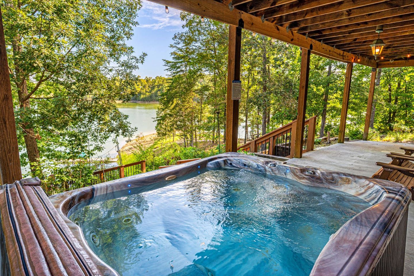 The hot tub on the lower porch looks straight out at Douglas Lake. Warm water behind you, the lake in front of you, and every good day here ends the same way.