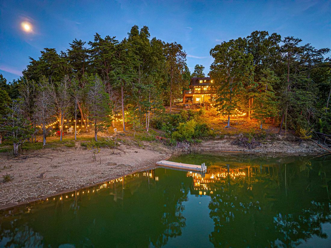 Kajun Kove lit up at twilight across Douglas Lake