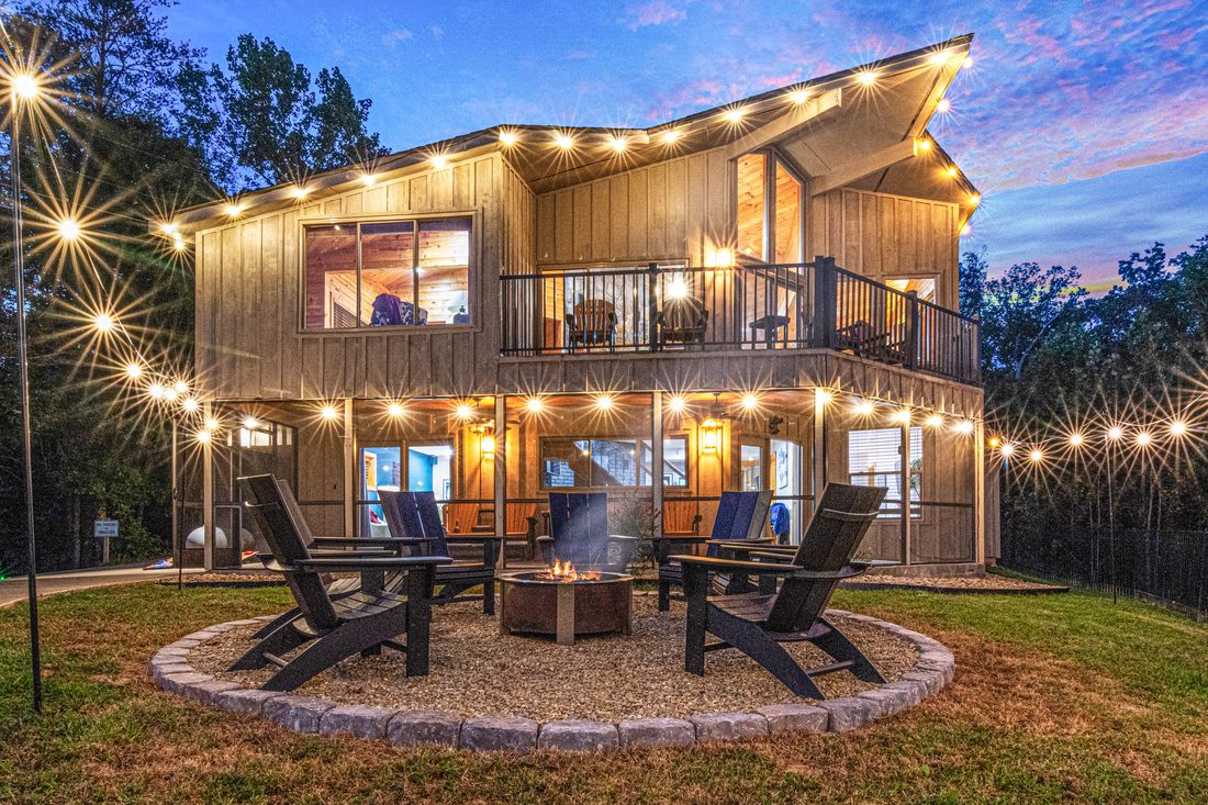 Birdsong Ridge lit up at twilight with string lights over the fire pit