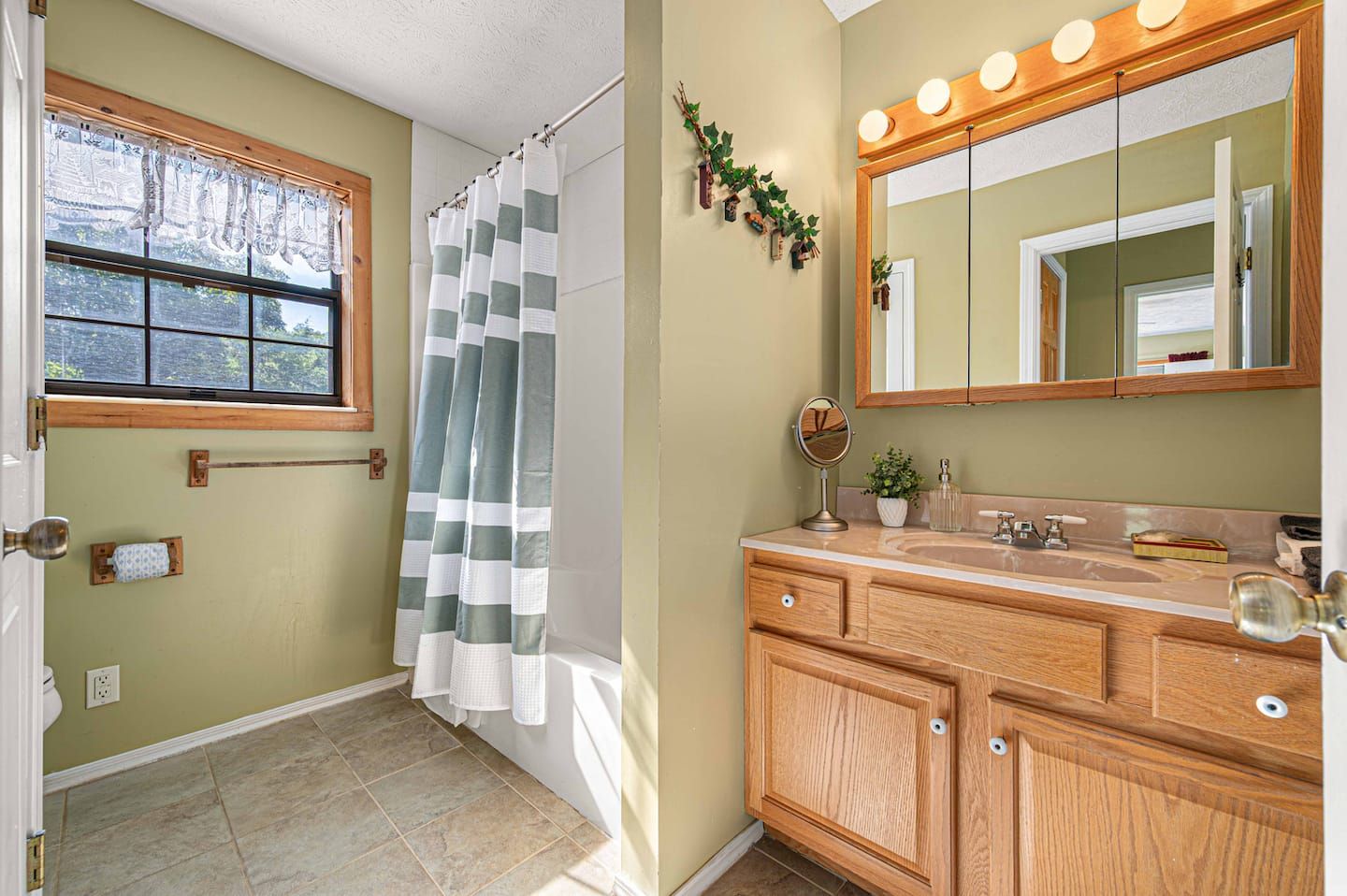 The main-level full bathroom, situated between the master bedroom and the kitchen.