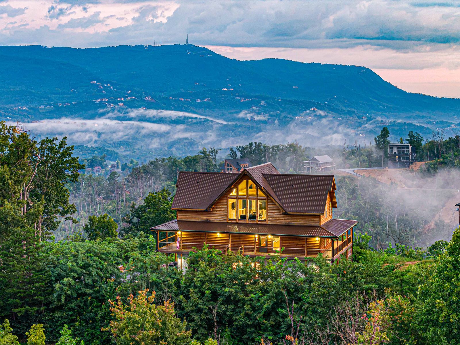 The cabin on its ridge with mist settling in the valleys below