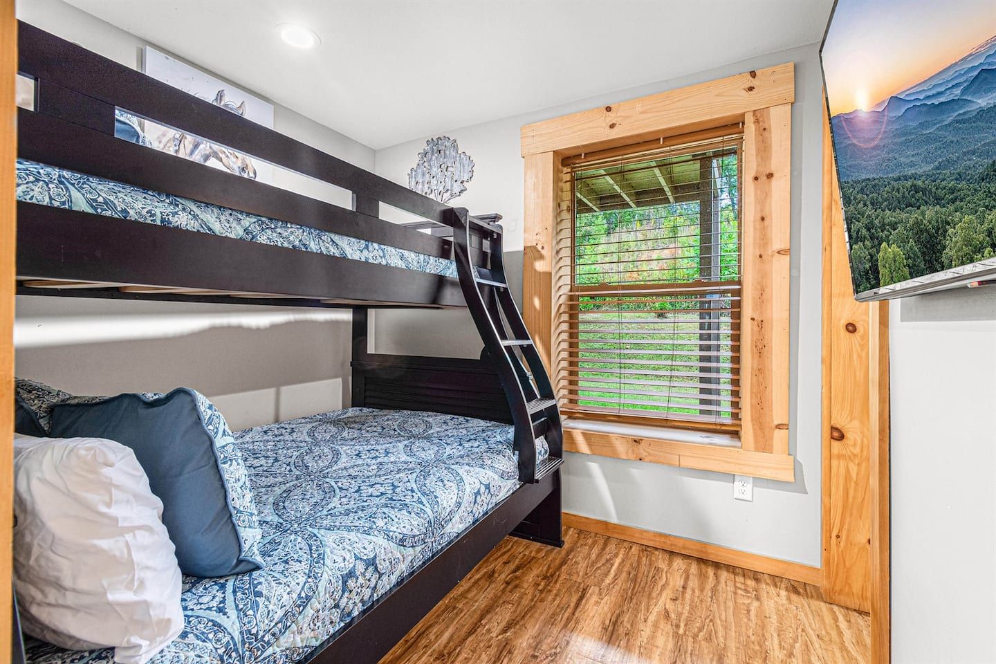 The downstairs bunk room has twin over full beds, a kid-friendly haven with an ensuite bathroom and Smart TV, providing private space for younger guests to unwind after a day of adventure. It’s perfect for bedtime stories or morning cartoons.