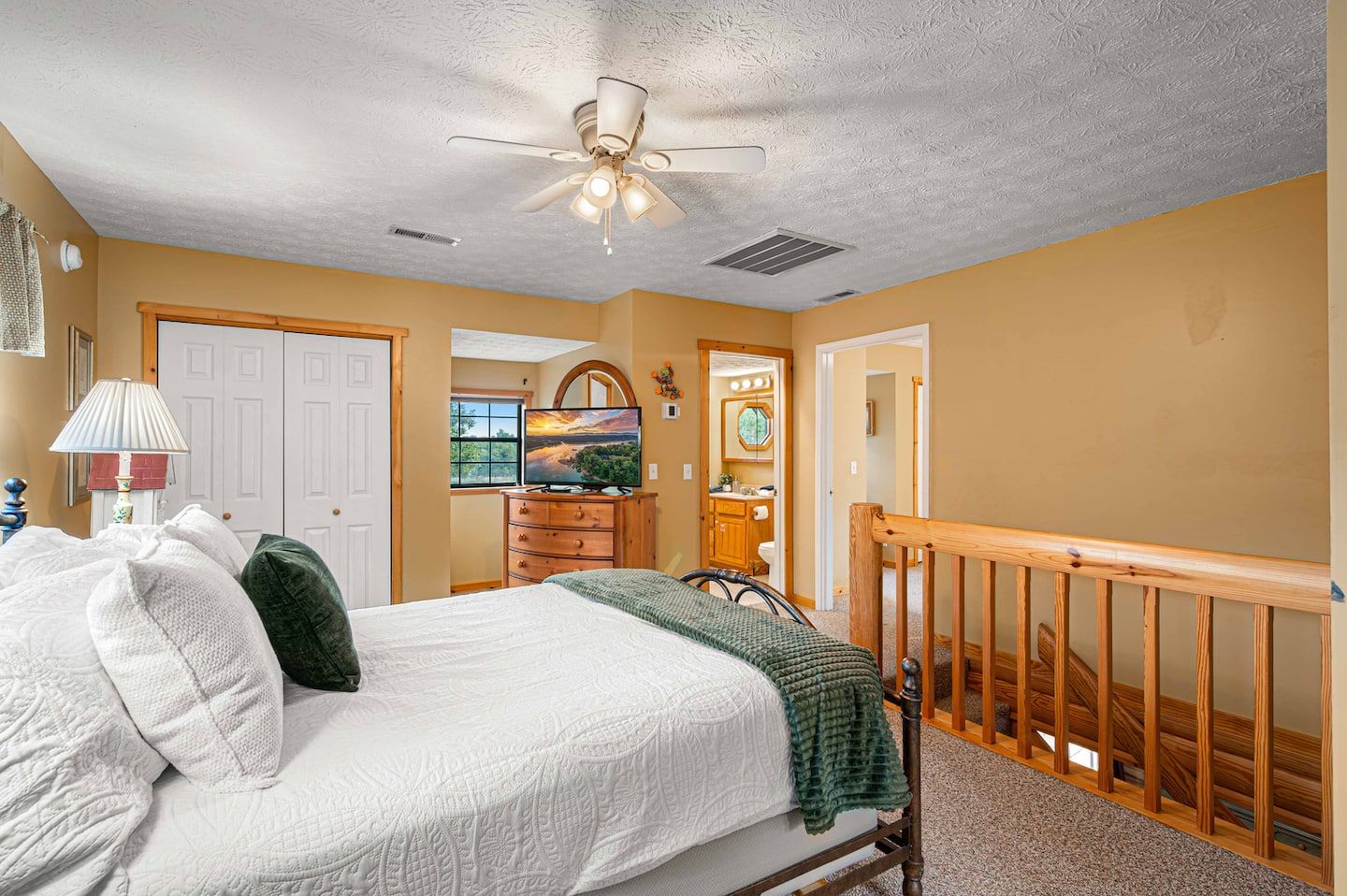 The loft's queen bed, tucked up above the main living space.
