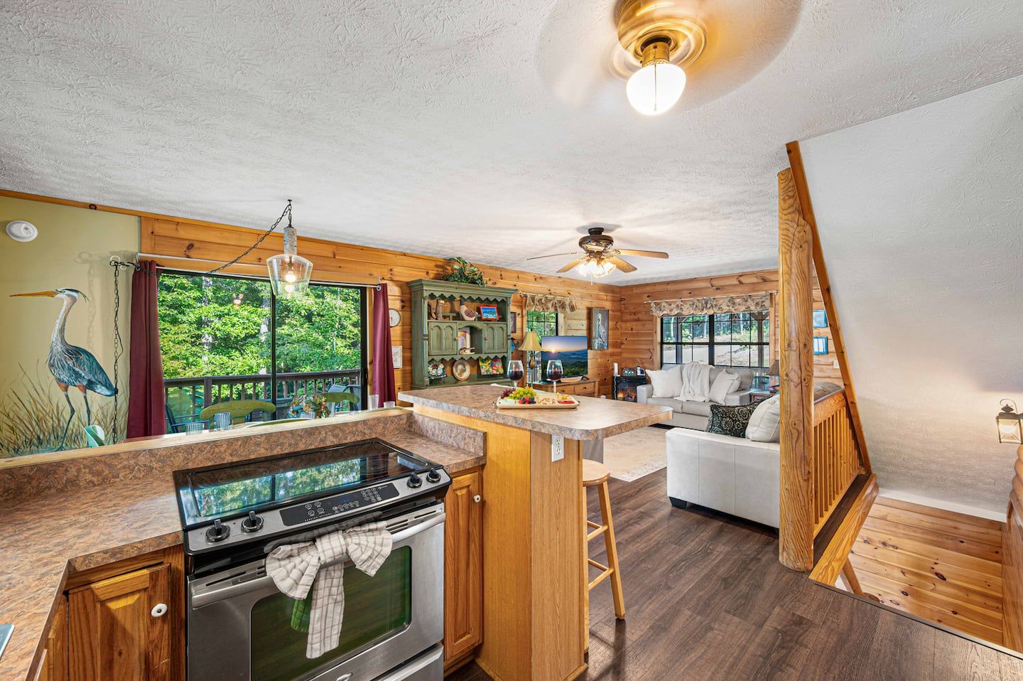 Full-size range, dishwasher, and plenty of counter space in the main-level kitchen, opening straight into the living room.
