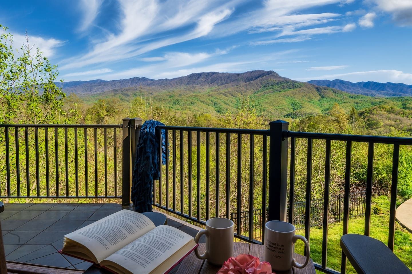 Morning coffee and a good book with the Smoky Mountains stretching before you — this is what a day at Birdsong Ridge looks like before it even begins.