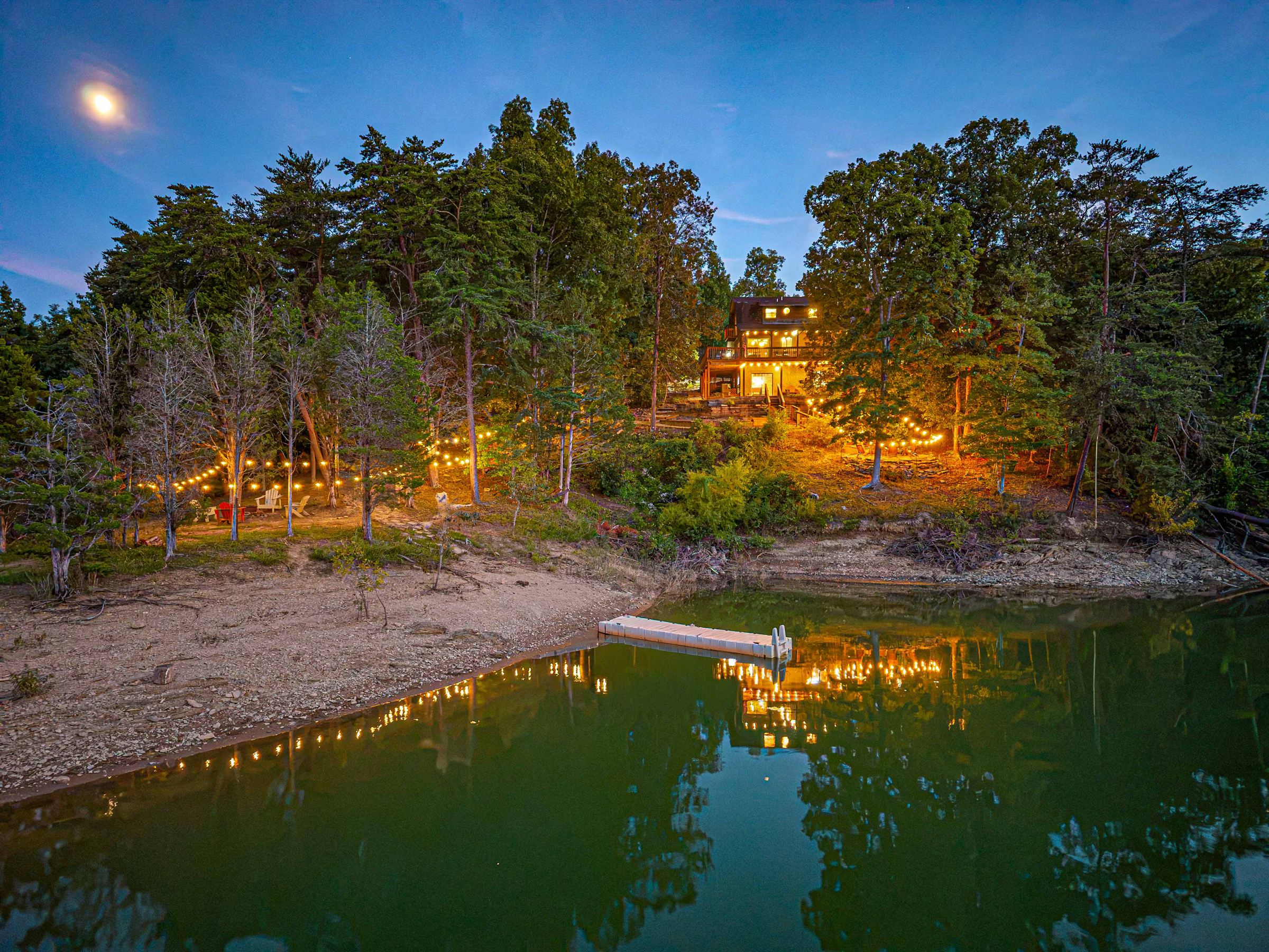 Kajun Kove lit up at twilight across Douglas Lake